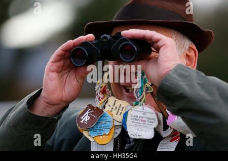 Un parieur ne regarde la course à travers une paire de jumelles à l'Hippodrome de Plumpton à Sussex, UK Banque D'Images