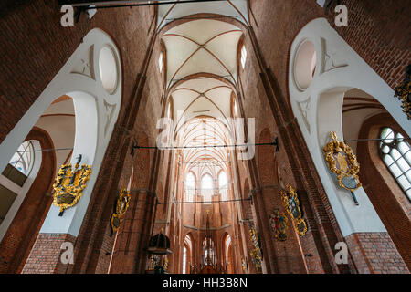 Riga, Lettonie - 1 juillet 2016 : le Quartier Gothique Ornate plafond voûté et des murs en brique avec les emblèmes de l'intérieur de St Peter's Evangelical Lutheran Ch Banque D'Images