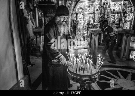 Un dignitaire religieux orthodoxe grec dans la Crucifixion autel dans l'église de Saint Sépulcre sur le Golgotha, Jérusalem, Israël Banque D'Images