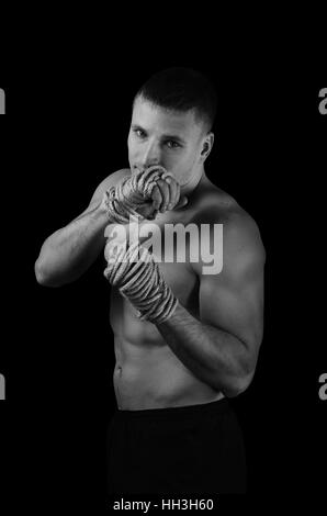 Photo en noir et blanc d'un jeune athlète avec des cordes de chanvre sur les mains pour le Muay Thai Banque D'Images