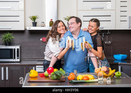 Deux jeunes femmes sont nourris de bananes midle age man Banque D'Images