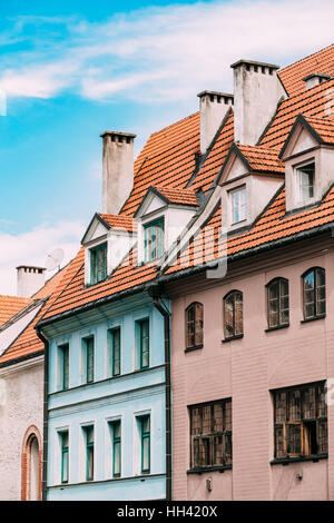 Riga, Lettonie. L'avis de tuile rouge avec toit en mansarde Gable quatre lucarnes sur la façade de l'ancien bâtiment sous ciel bleu. Banque D'Images