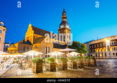 Riga, Lettonie. Vue de la cathédrale du dôme lumineux, éclairage en soirée médiévale monument architectural de la vieille ville, célèbre monument et terrasse extérieure d'été Banque D'Images