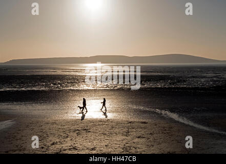 Les promeneurs de chiens sur la plage le long d'une journée d'hiver de Weston-super-Mare, Angleterre Banque D'Images