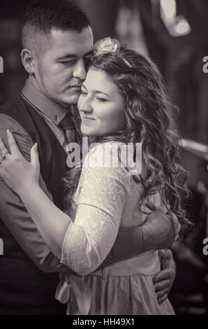 Le jeune couple aimant embrasse et l'embrasse. La jeune fille en robe blanche, l'homme dans un gilet. Wedding Banque D'Images