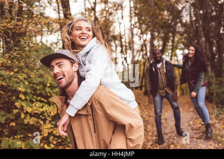 Groupe de jeunes amis heureux et s'amusant en jumelant les forêt d'automne Banque D'Images