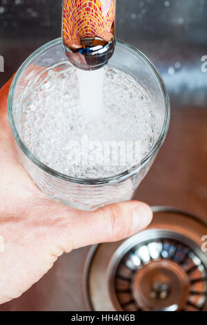 Capture d'un point de vue d'un homme de servir un verre d'eau douce dans un robinet de cuisine Banque D'Images