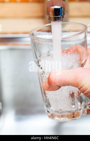 Capture d'un point de vue d'un homme de servir un verre d'eau douce dans un robinet de cuisine Banque D'Images