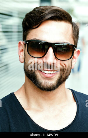 Portrait d'un homme heureux et beau avec des lunettes de soleil Banque D'Images