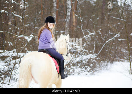 Jeune fille à cheval en hiver albinos forest Banque D'Images