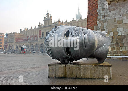 Cracovie, Pologne - 4 janvier 2011 : sculpture tête Eros Bendato sur place du marché par l'artiste polonais Igor Mitoraj avec Sukiennice halle aux draps on background Banque D'Images