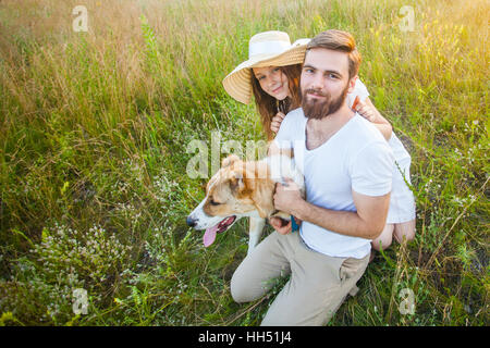 Beau couple heureux avec leur chien Alabai dans la nature avec le coucher du soleil. Banque D'Images