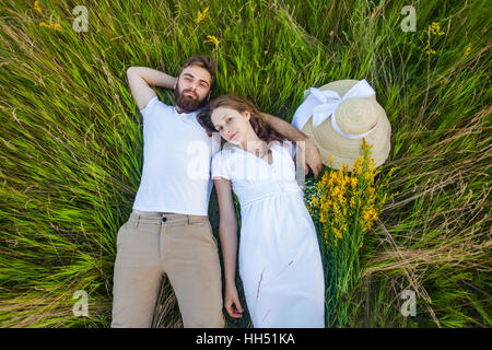 Happy young couple in love détendue portant sur l'herbe frais généraux Banque D'Images