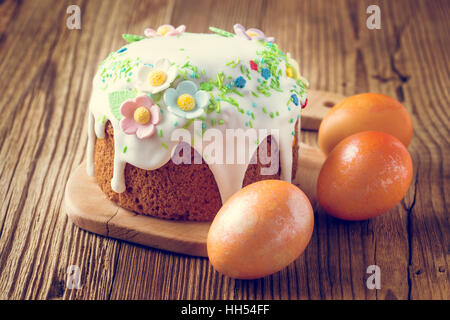 Gâteau de pâques avec glace décoration glacer et œufs de Pâques colorés sur une table en bois rustique Banque D'Images