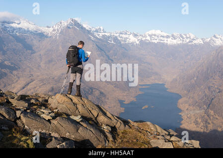 Walker surplombant Loch Coruisk et les Cuillin de Sgurr na ires sur l'île de Skye, en Ecosse. Banque D'Images