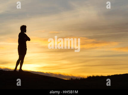 Les promeneurs de chiens à regarder le coucher du soleil sur le haut de la colline de Blackford, Édimbourg, Écosse Banque D'Images