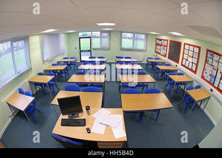 Vue grand angle d'une salle de classe nouvellement construite avec des bureaux et des chaises dans une configuration traditionnelle, face au bureau du professeur. Vide, pas d'élèves. Banque D'Images