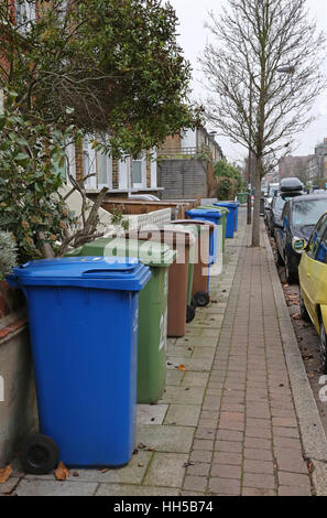 Plusieurs wheelie-poubelles pour déchets domestiques recyclés obstruent la chaussée au sud de Londres. Bleu, vert et marron poubelles pour déchets triés. Banque D'Images