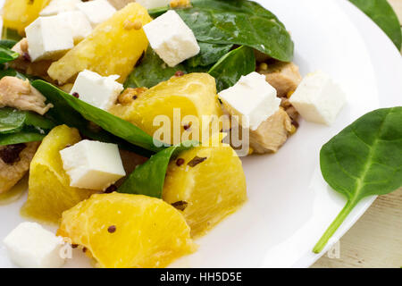 Garni de salade Feta couper des épinards, poulet et orange on white plate Banque D'Images