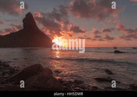 Spectaculaire coucher de soleil derrière le rocher "orro do Pico', 'l'île de Fernando de Noronha' , Océan Atlantique, Pernambuco, Brésil Banque D'Images