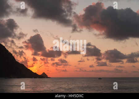 Spectaculaire coucher de soleil derrière le rocher "orro do Pico', 'l'île de Fernando de Noronha' , Océan Atlantique, Pernambuco, Brésil Banque D'Images