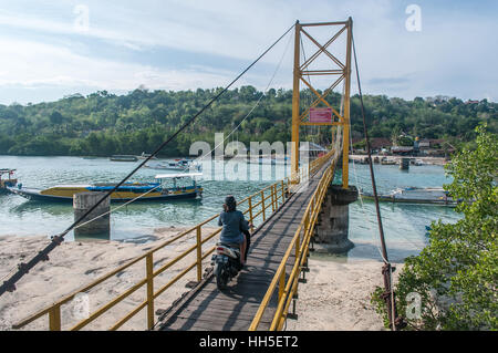 Femme avec passage du pont suspendu de moto jaune, nusa ceningan lembongan, Bali, Indonésie Banque D'Images