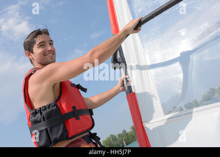 Beau jeune windsurfer sur l'eau Banque D'Images