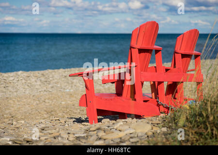 Muskoka Chaises rouge sur les rives de la baie Georgienne. Meubles De Patio donnant sur les Grands Lacs au cours d'une calme belle journée d'été. Se détendre. Banque D'Images