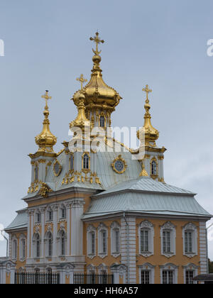 Extérieur blanc et jaune de la Chapelle Impériale de Peterhof Palace avec dômes oignon d'or surmontées de croix orthodoxe. Banque D'Images