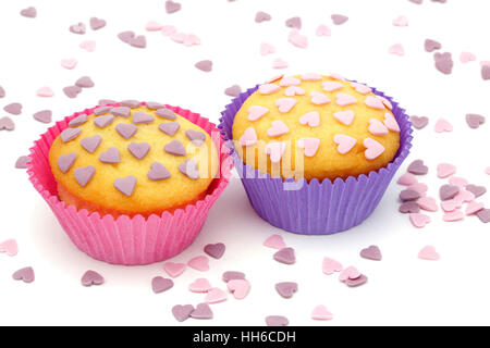 Deux cupcakes avec petit coeur rose et pourpre Banque D'Images
