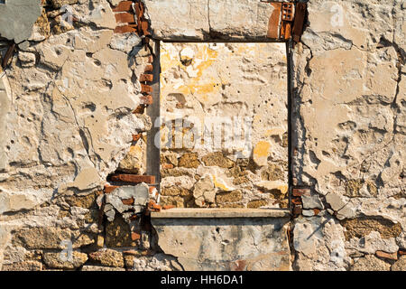 Vue de la fenêtre : les murs intérieurs et extérieurs d'un bâtiment abandonné WW2 sur l'île de Sardaigne ; Baia Sardinia, Italie. Banque D'Images