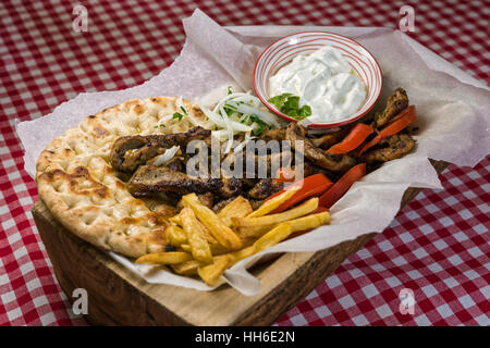 Viande gyros grec fait maison avec sauce tzatziki, tomates et frites Banque D'Images