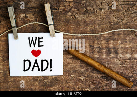 Cigare sur planche en bois et panneau blanc avec les mots que nous aimons Papa Banque D'Images