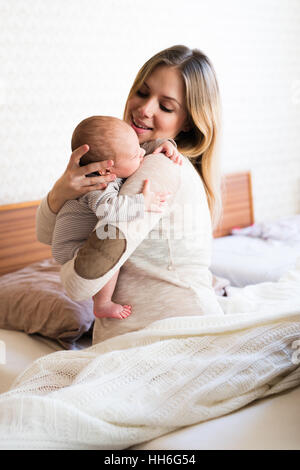 Belle jeune mère tenant dans ses bras son bébé Banque D'Images