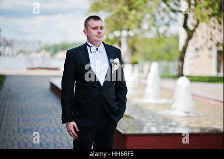 Portrait de groom élégant smoking en contexte de la fontaine. Banque D'Images