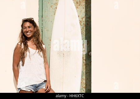 Fille avec un stand en face de surf grunge porte. Banque D'Images