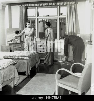 1950, historiques, étudiant de troisième cycle à l'étranger nouvellement arrivé à l'Institut de l'éducation (OIE) est montré sa chambre dans un hôtel de Londres. Banque D'Images