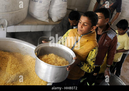 Sanaa, Yémen. 17 Jan, 2017. Les orphelins se transportant leurs boîtes repas au restaurant de l'institution des orphelins à Sanaa, Yémen, le 17 janvier 2017. Il y a plus de 700 enfants de tous les différents gouvernorats d'orphelins vivant dans les maisons de l'Institution à Sanaa. Les orphelins du Yémen sont durement touchées par la guerre, avec la diminution du financement accordé à un gouvernement et non-gouvernement exécutant des orphelinats à travers le pays, ainsi que de dons de particuliers et d'initiatives s'est tari. Credit : Mohammed Mohammed/Xinhua/Alamy Live News Banque D'Images