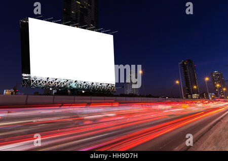 Blank billboard sur light trails, street et urbain dans le crépuscule, nuit - pouvez publicité pour afficher ou un montage produits ou entreprise. Banque D'Images