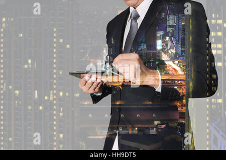 Double exposition de businessman working with tablet, ville de nuit et night street Banque D'Images