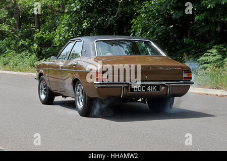 La fumée des pneus d'un épuisement professionnel de patinage de roue par un 1972 Ford Cortina Mk3 style Gasser, hot rod custom car Banque D'Images