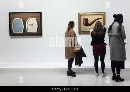 Visiteurs en face de la peinture 'La trahison des images' ('la trahison des images') par l'artiste surréaliste belge René Magritte (1929) affichée à son exposition rétrospective au Centre Pompidou à Paris, France. Les Français inscription 'Ceci n'est pas une pipe" veut dire "Ce n'est pas une pipe'. La peinture 'Le Palais des rideaux III' ('Le Palais de rideaux III') par René Magritte (1928-1929) est vue à la gauche. L'exposition intitulée "René Magritte. La trahison des images' tourne au 23 janvier 2017. Banque D'Images