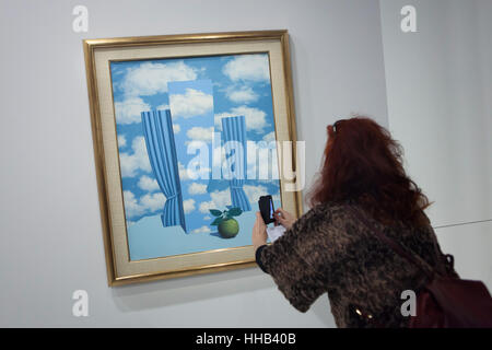 Visiteur utilise un smartphone pour photographier le tableau Le Beau Monde (le beau monde, 1962) par l'artiste surréaliste belge René Magritte affichée à son exposition rétrospective au Centre Pompidou à Paris, France. L'exposition intitulée "René Magritte. La trahison des images' tourne au 23 janvier 2017. Après que la version reformulée de l'exposition sera présentée à la Schirn Kunsthalle Frankfurt am Main, Allemagne, du 10 février au 5 juin 2017. Banque D'Images