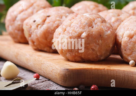 Boulettes de brut sur une planche à découper et d'ingrédients. macro à l'horizontale. Banque D'Images