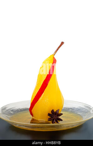 Seule poire pochée au sirop de sucre et de safran épicé de piment rouge et d'anis étoilé sur un tableau noir avec fond blanc Banque D'Images