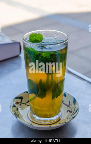 Doux traditionnel thé marocain avec les feuilles de menthe dans grand verre sur table à l'extérieur, le Maroc, l'Afrique du Nord Banque D'Images