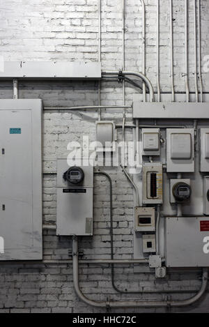 Électriques et des boîtes et un compteur reader sur un mur de brique peint Banque D'Images