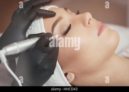 Close up cosmetologist faire maquillage permanent eyeliner Banque D'Images