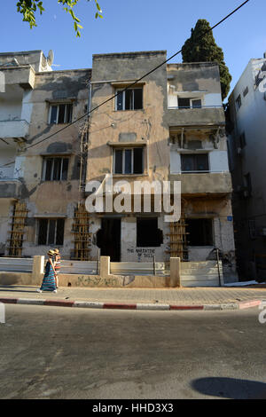Deux femmes passent devant un vieil immeuble de style Bauhaus et délabrées à Tel Aviv, Israël. / © Craig M. Eisenberg Banque D'Images