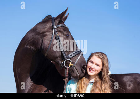 Cheval de Hanovre. Jeune femme smooching avec black mare. Allemagne Banque D'Images